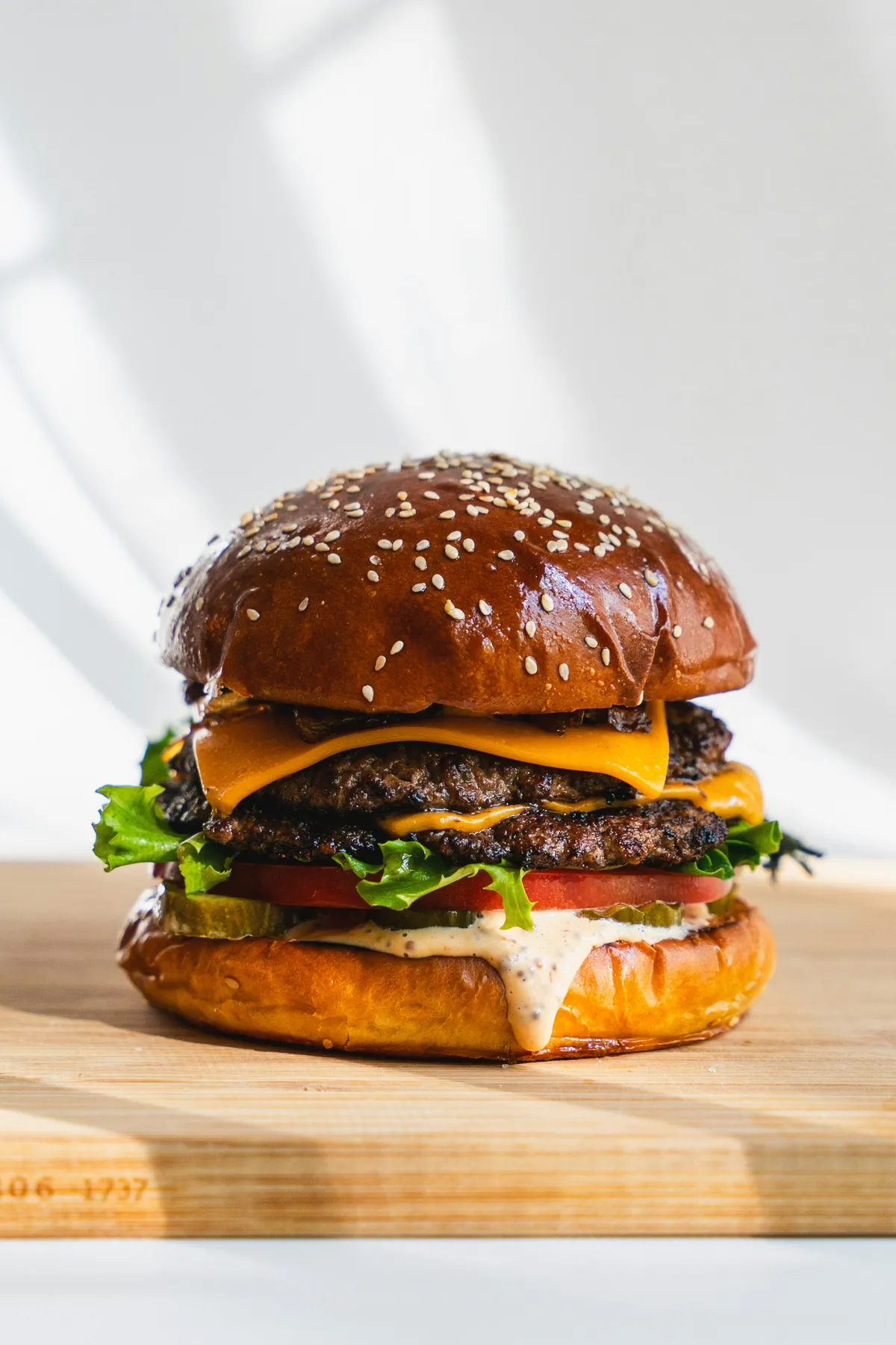 Smash burger doble con cheddar sobre tabla de madera